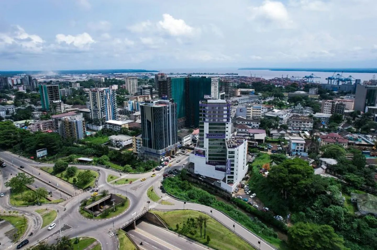 Vue panoramique de Douala montrant les gratte-ciel du quartier d'affaires de Bonanjo et les pirogues traditionnelles sur le fleuve Wouri.